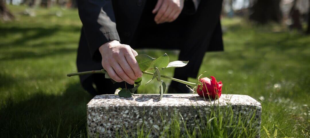 man-bringing-rose-tombstone-cemetery